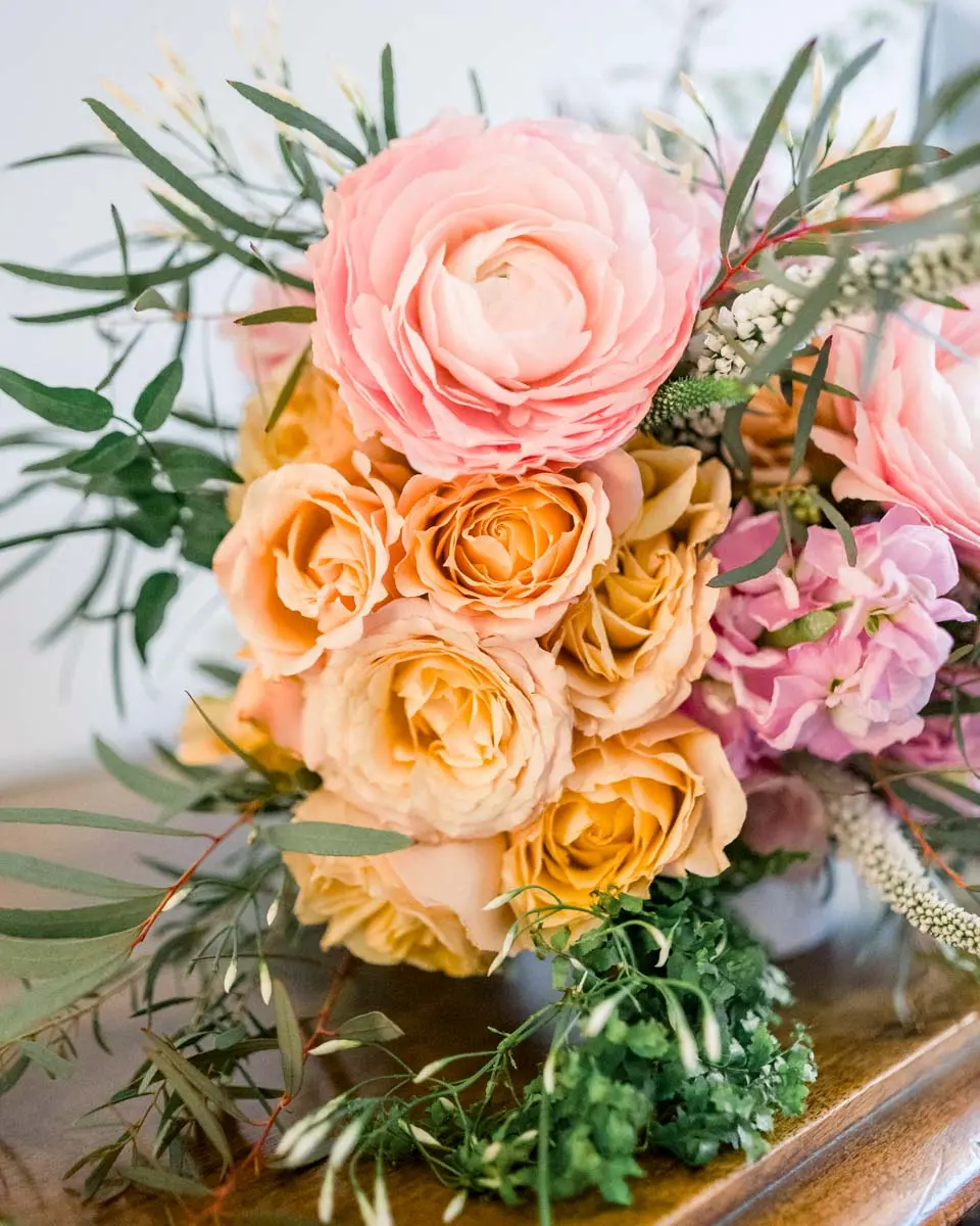 Detail of the ranunculus and peach roses in the bridal bouquet