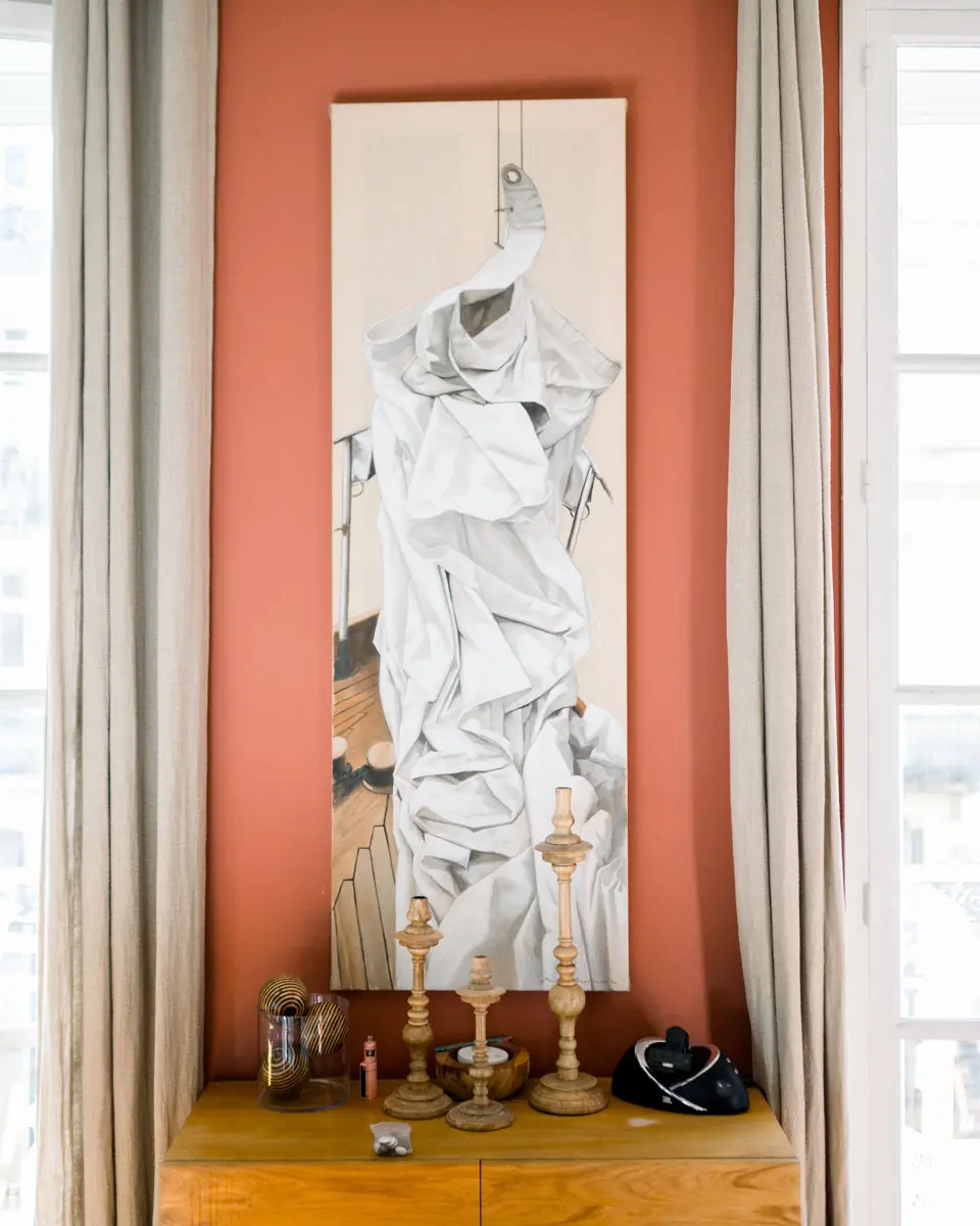 White draped sculpture in an orange wall niche with candlesticks below