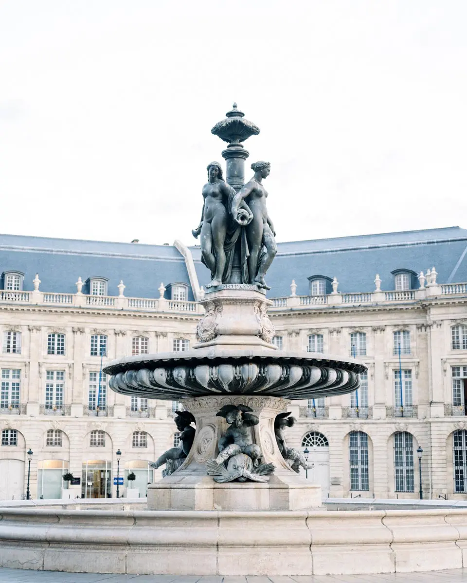 Fountain before the classical facades of Place de la Bourse in Bordeaux