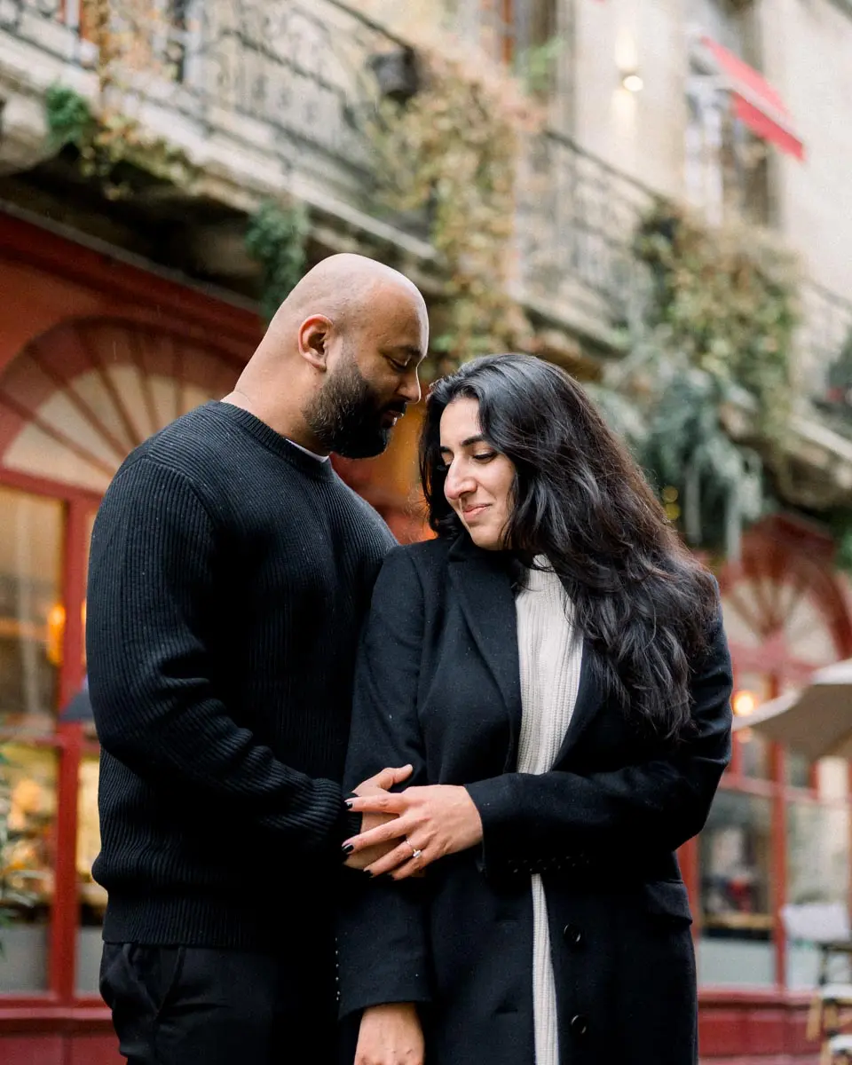 Nisha nestled against Hardik before a flower-decked facade in Bordeaux
