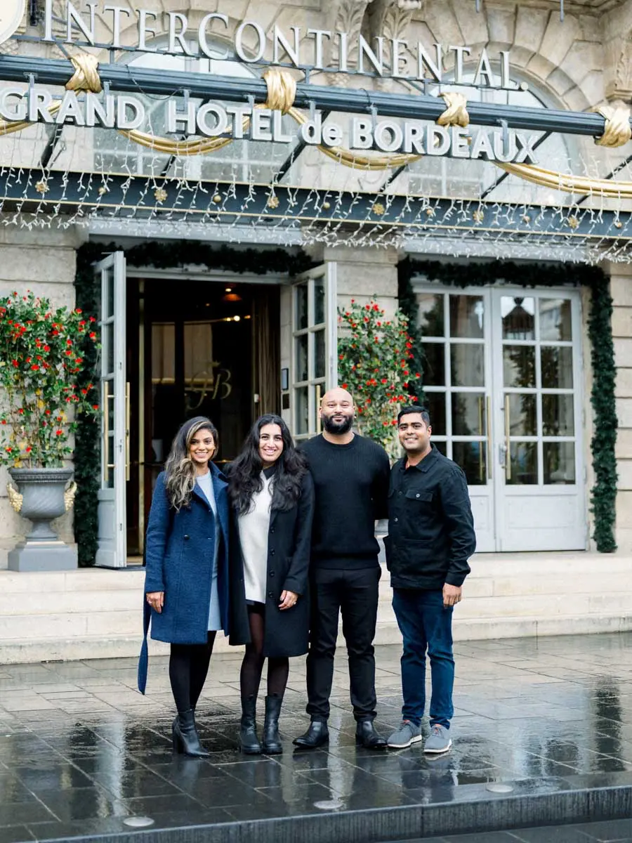 Engaged couple and loved ones at the entrance of the Grand Hôtel de Bordeaux