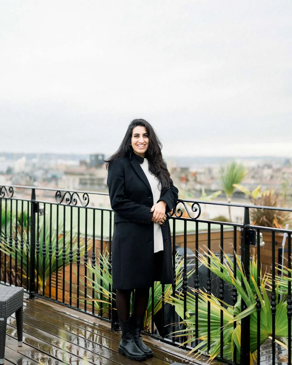 Nisha leaning on the rooftop railing overlooking Bordeaux