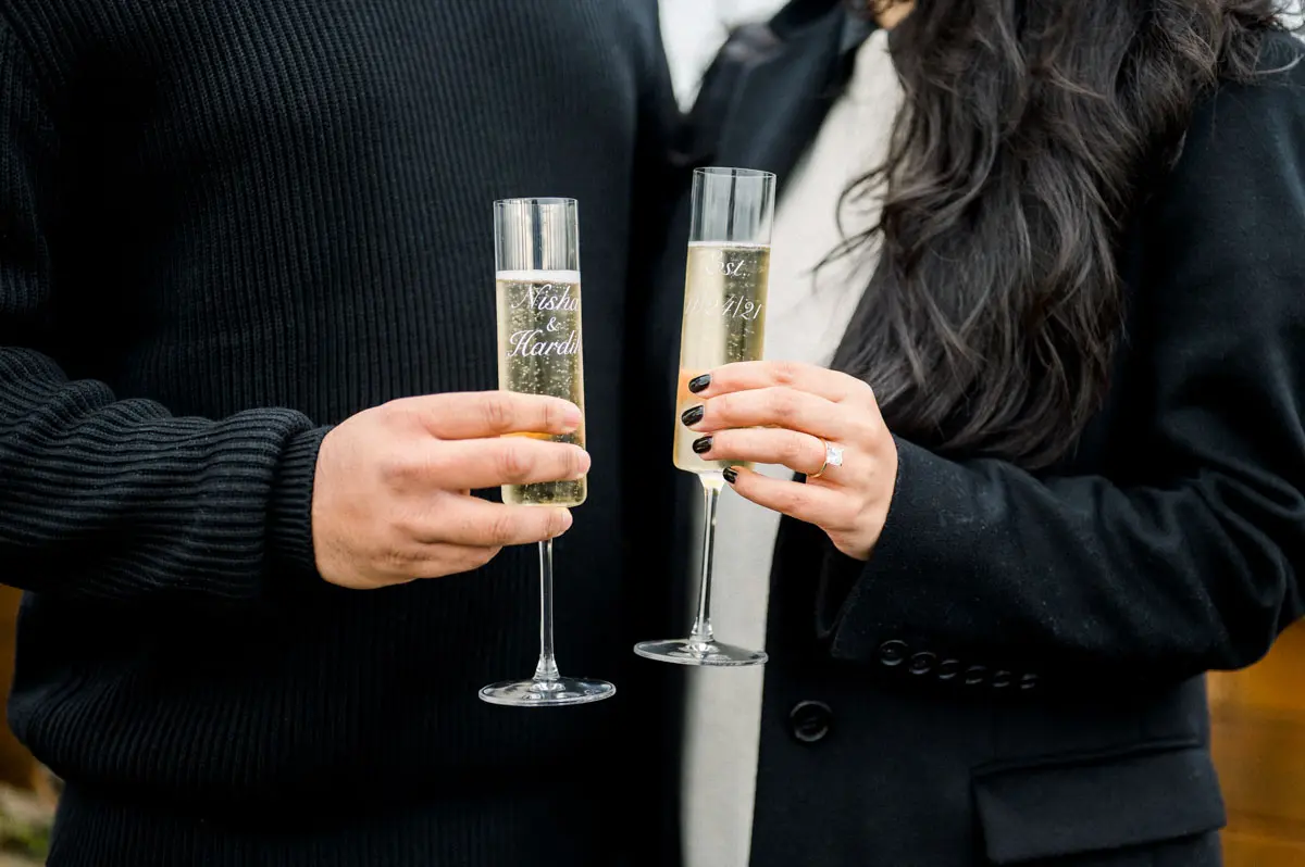 Engaged couple toasting with champagne, engagement ring on her finger