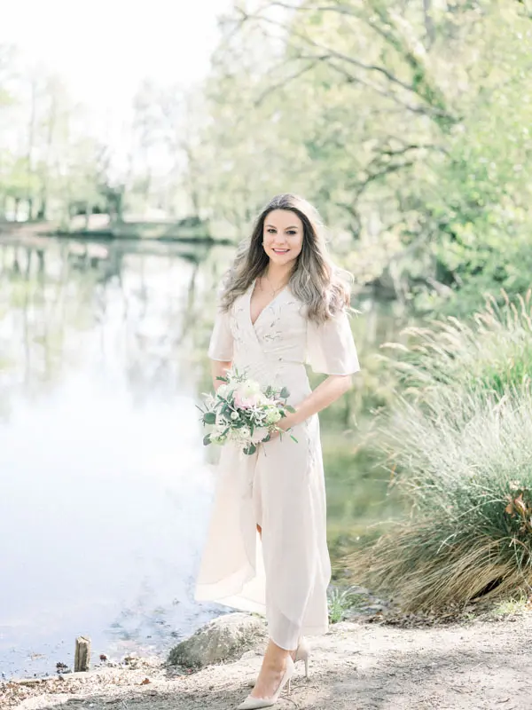Bride-to-be in a cream dress at the water's edge in Parc Majolan