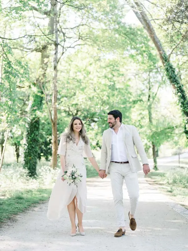 Simone and Julien strolling hand in hand along a shady path