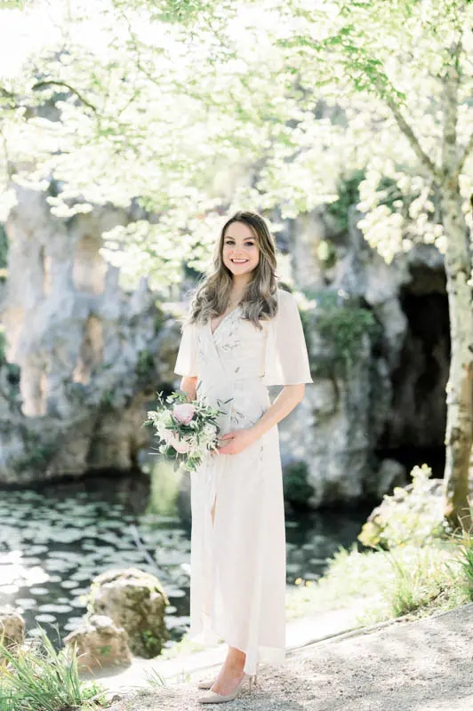 Bride-to-be in front of the Parc Majolan grottoes, bouquet in hand