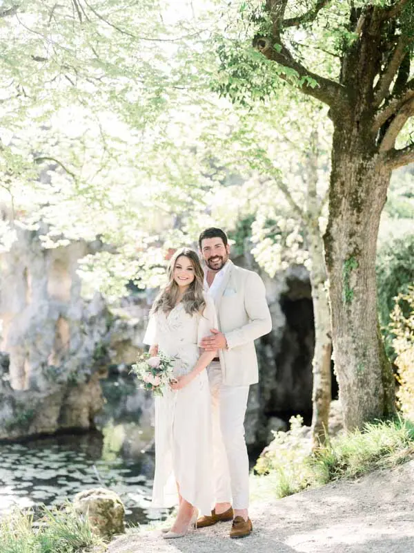 Simone and Julien embracing beneath a large tree near the grottoes