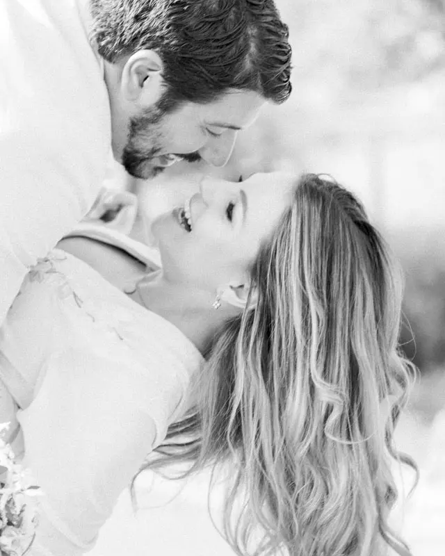 The couple laughing cheek to cheek, in black and white