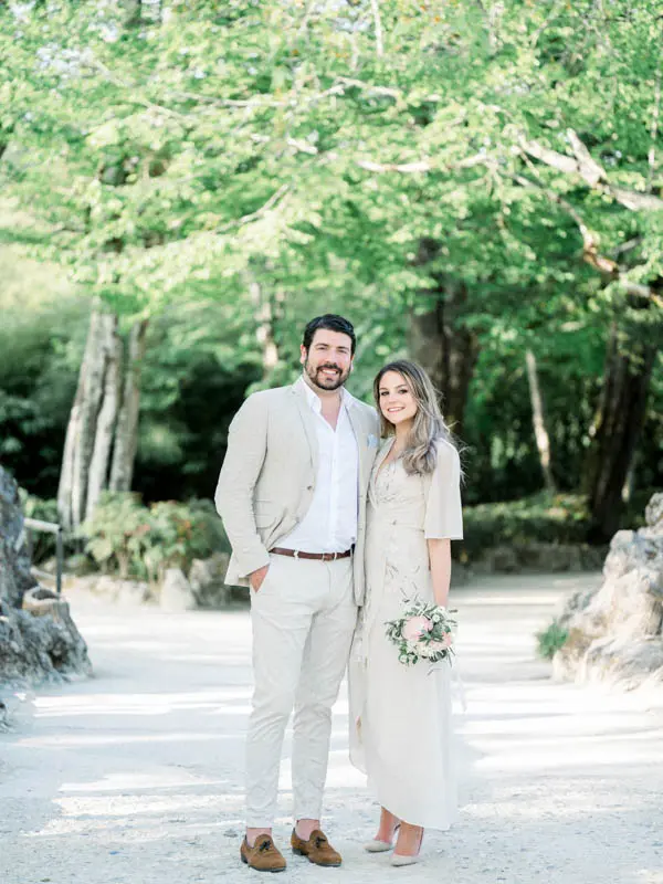 The smiling couple posing side by side on a pale park path