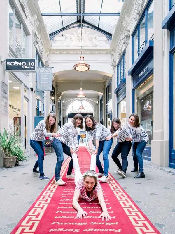 Friends in striped tops around the bride-to-be in the Passage Sarget, Bordeaux hen party