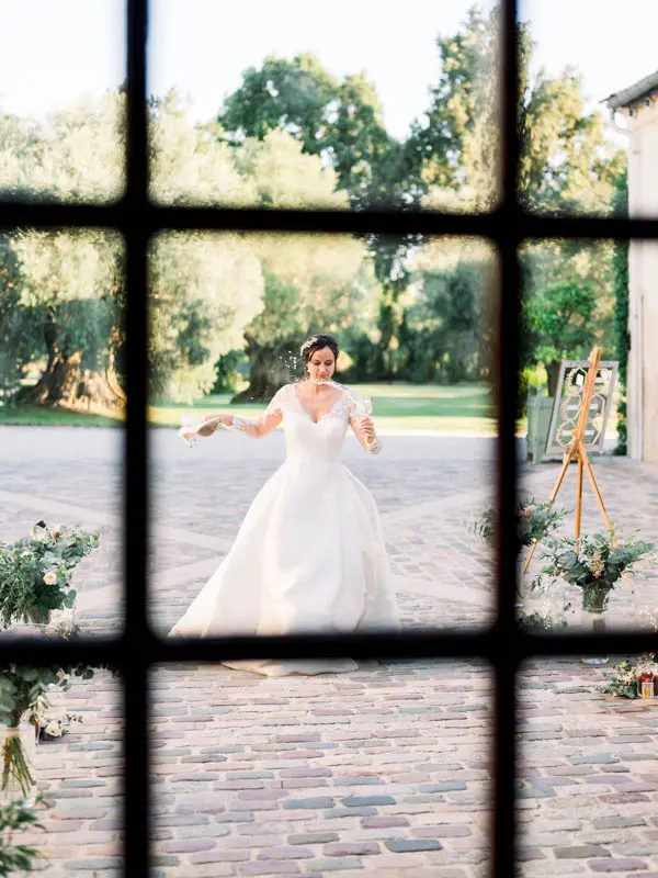 Bride in the courtyard seen through a leaded window