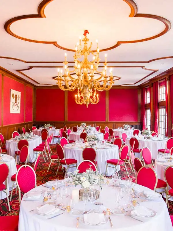 Red reception room set for a wedding dinner at Château Pape Clément