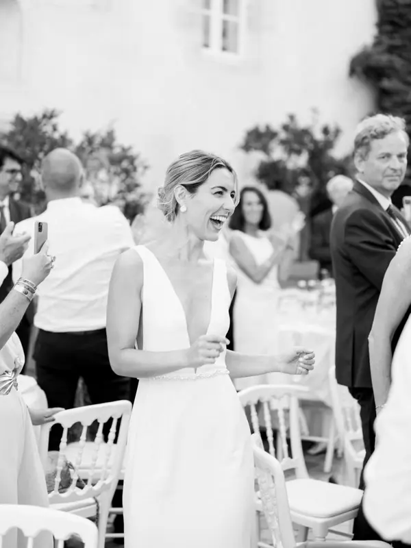 Bride laughing with her guests, black and white, Château Pape Clément