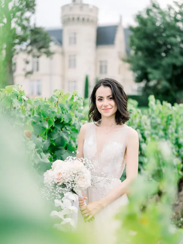 Bride in the vineyards with Château Pape Clément behind her