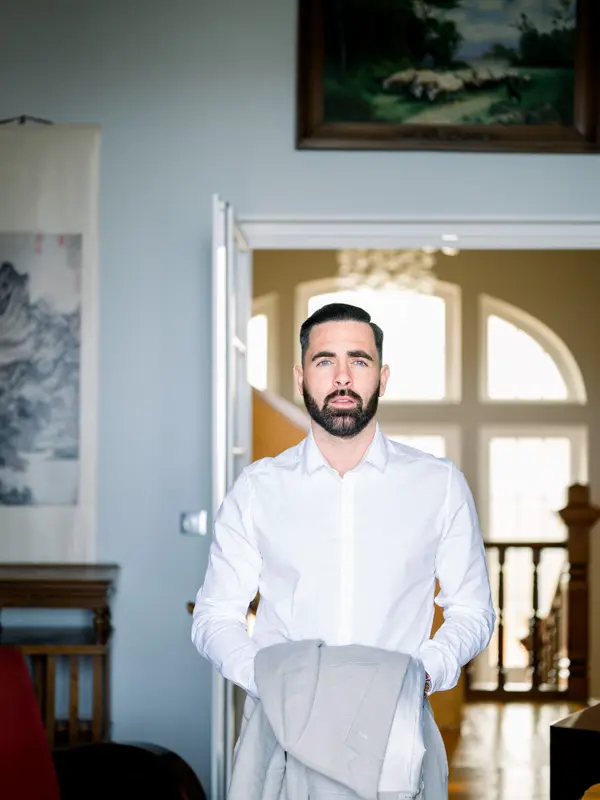 Marié tenant sa veste pendant les préparatifs à la Villa La Tosca