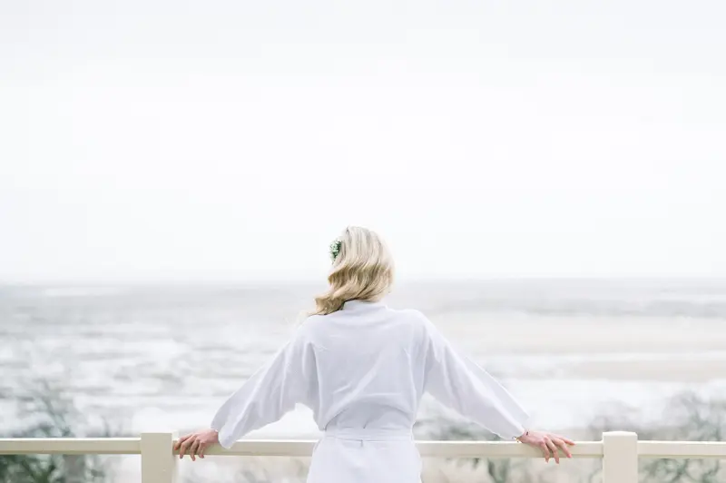 Bride in a robe on the balcony overlooking Arcachon Bay