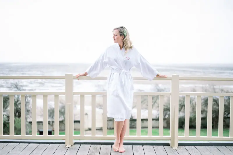 Bride in a robe on the balcony overlooking Arcachon Bay