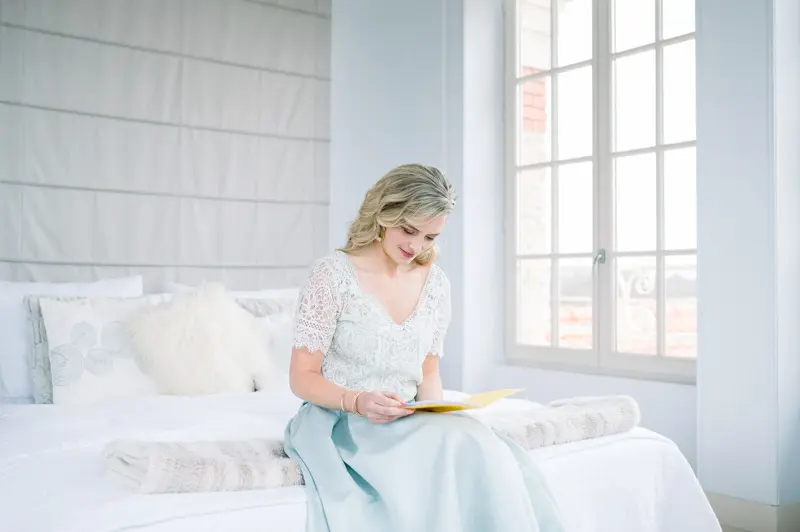 Bride writing in a bright bedroom at Villa La Tosca