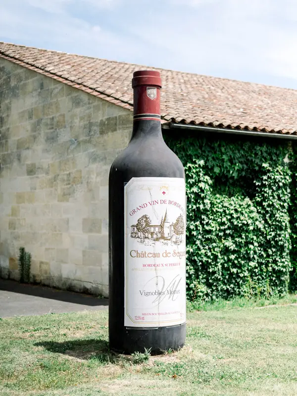 Giant Château de Seguin wine bottle in front of the cellars