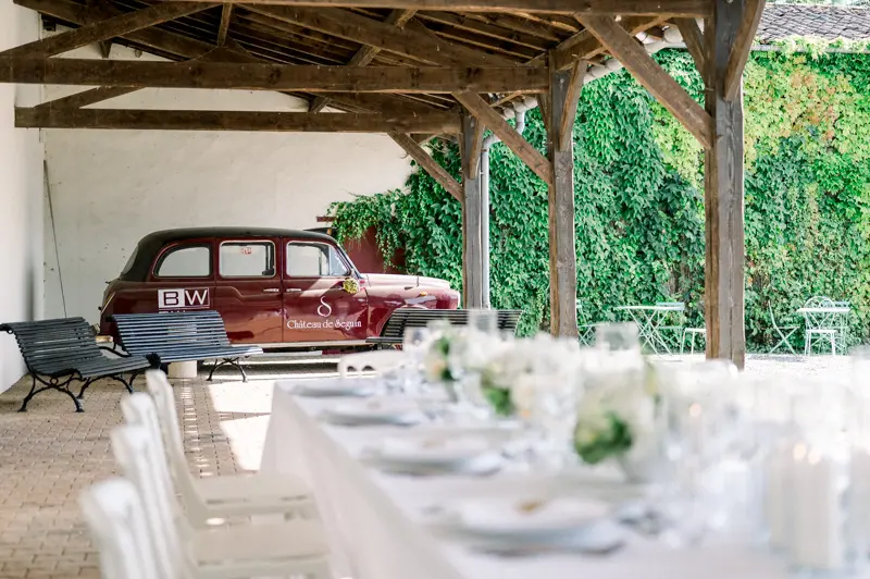 Tables under the covered terrace with a vintage car, Château de Seguin