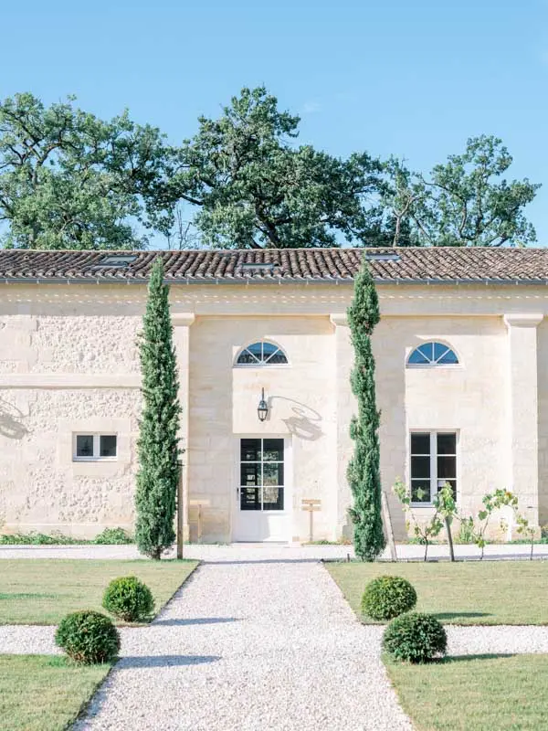 Stone façade and cypress-lined path at Château Gassies