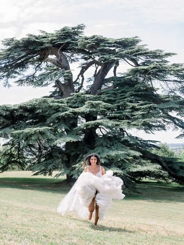Bride running beneath the cedar of Lebanon at Château Gassies