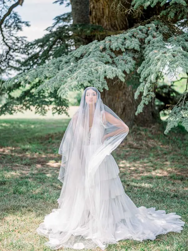 Bride with a long veil beneath the cedar at Château Gassies