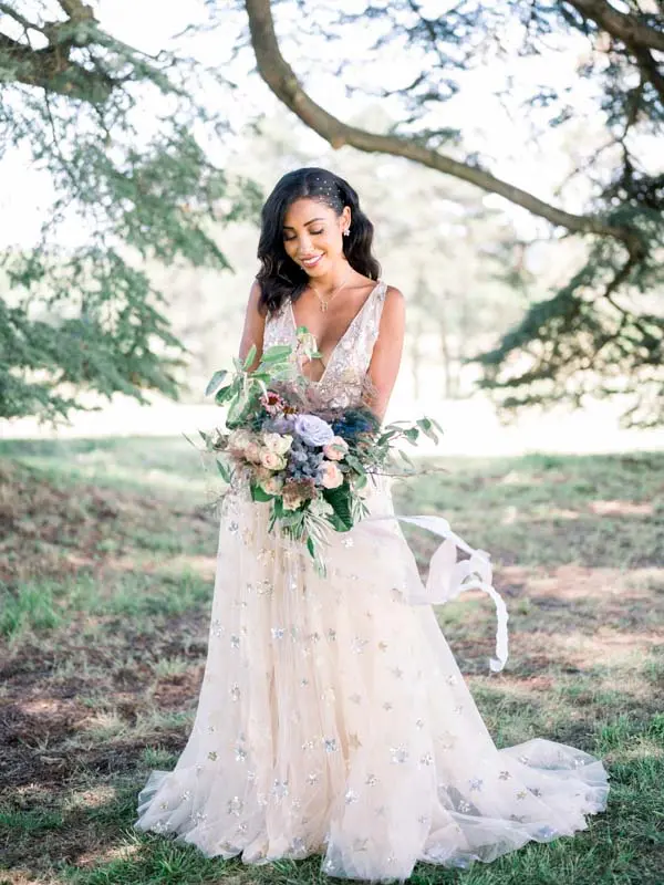 Bride holding a pastel bouquet in the park of Château Gassies