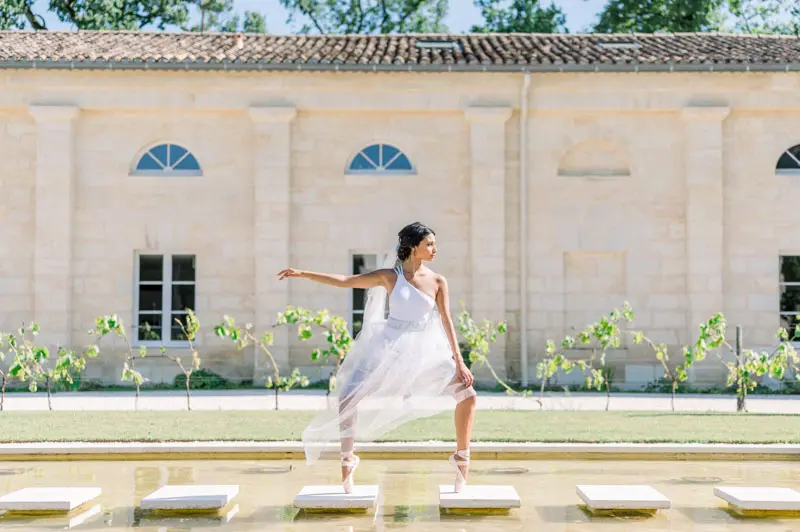 Bride dancing across the reflecting pool at Château Gassies