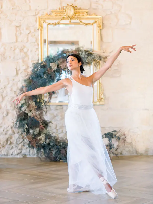 Bride dancing beneath a gilded mirror and floral wreath, Château Gassies