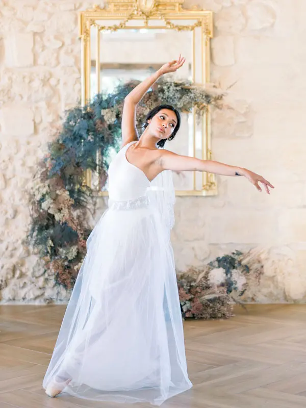 Bride dancing beneath a gilded mirror and floral wreath, Château Gassies