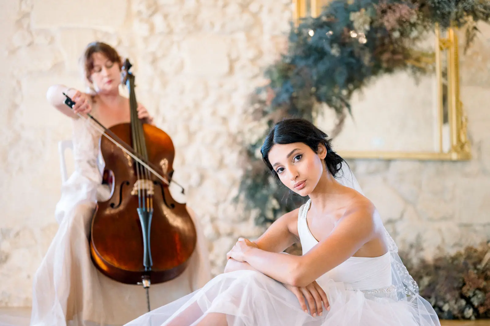 Cellist and bride in a stone-walled room at Château Gassies