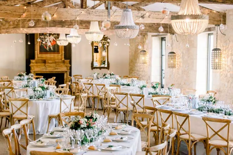 Wedding reception hall with oak beams and chandeliers at Château de Garde