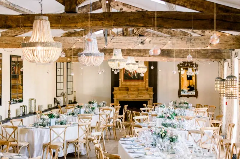 Wedding reception hall with oak beams and chandeliers at Château de Garde