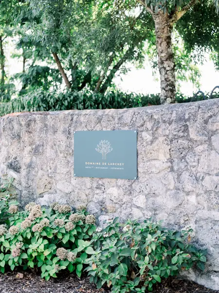 Stone wall and sign at the entrance to Domaine de Larchey