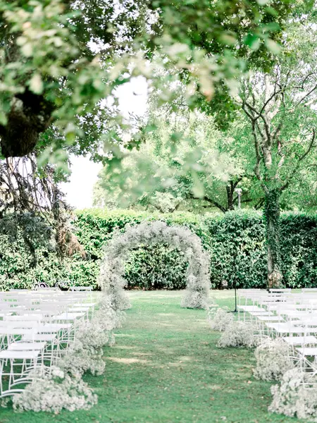 Outdoor ceremony with a gypsophila arch beneath the oaks, Domaine de Larchey