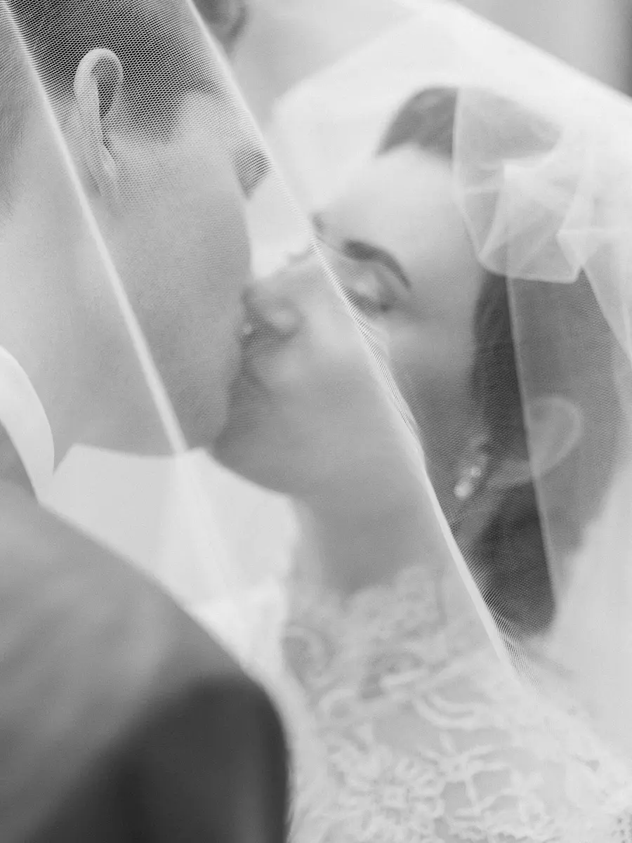 Baiser des mariés sous le voile, en noir et blanc