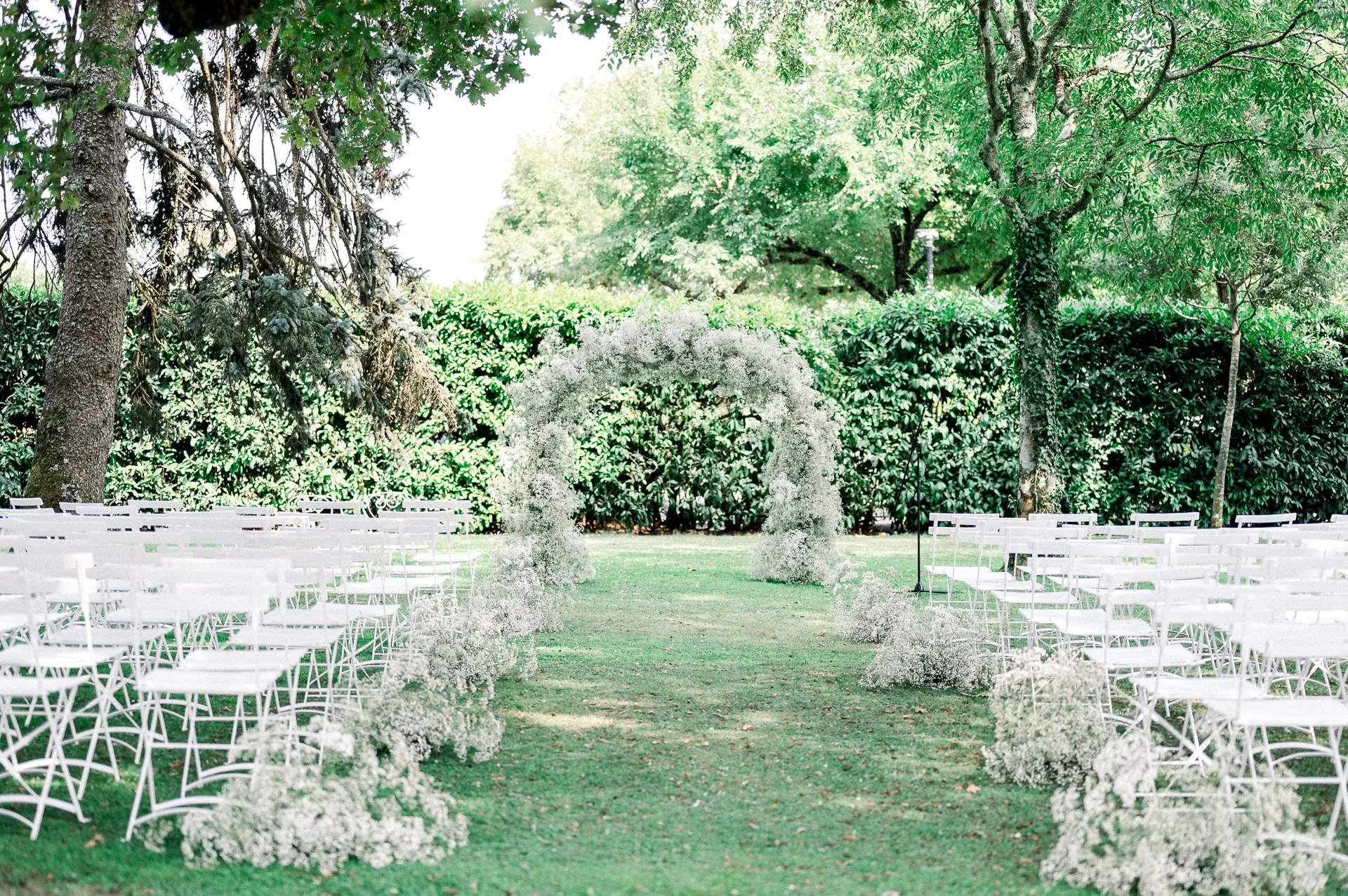 Cérémonie en plein air sous une arche de gypsophile au Domaine de Larchey