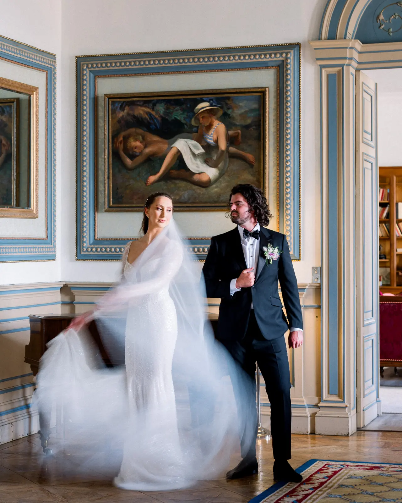 Bride twirling her gown beside the groom in a salon at Château de la Valouze, Dordogne