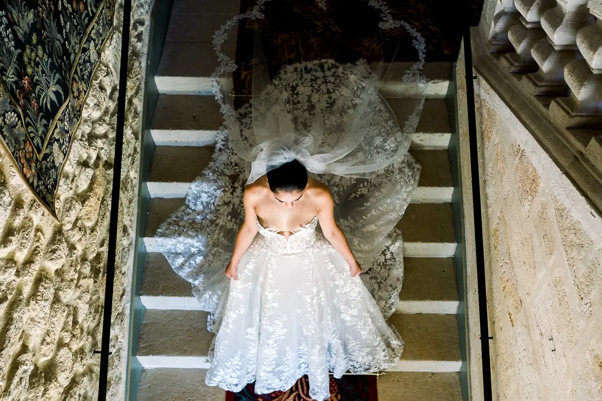 Robe de mariée en dentelle vue d'en haut dans un escalier en pierre