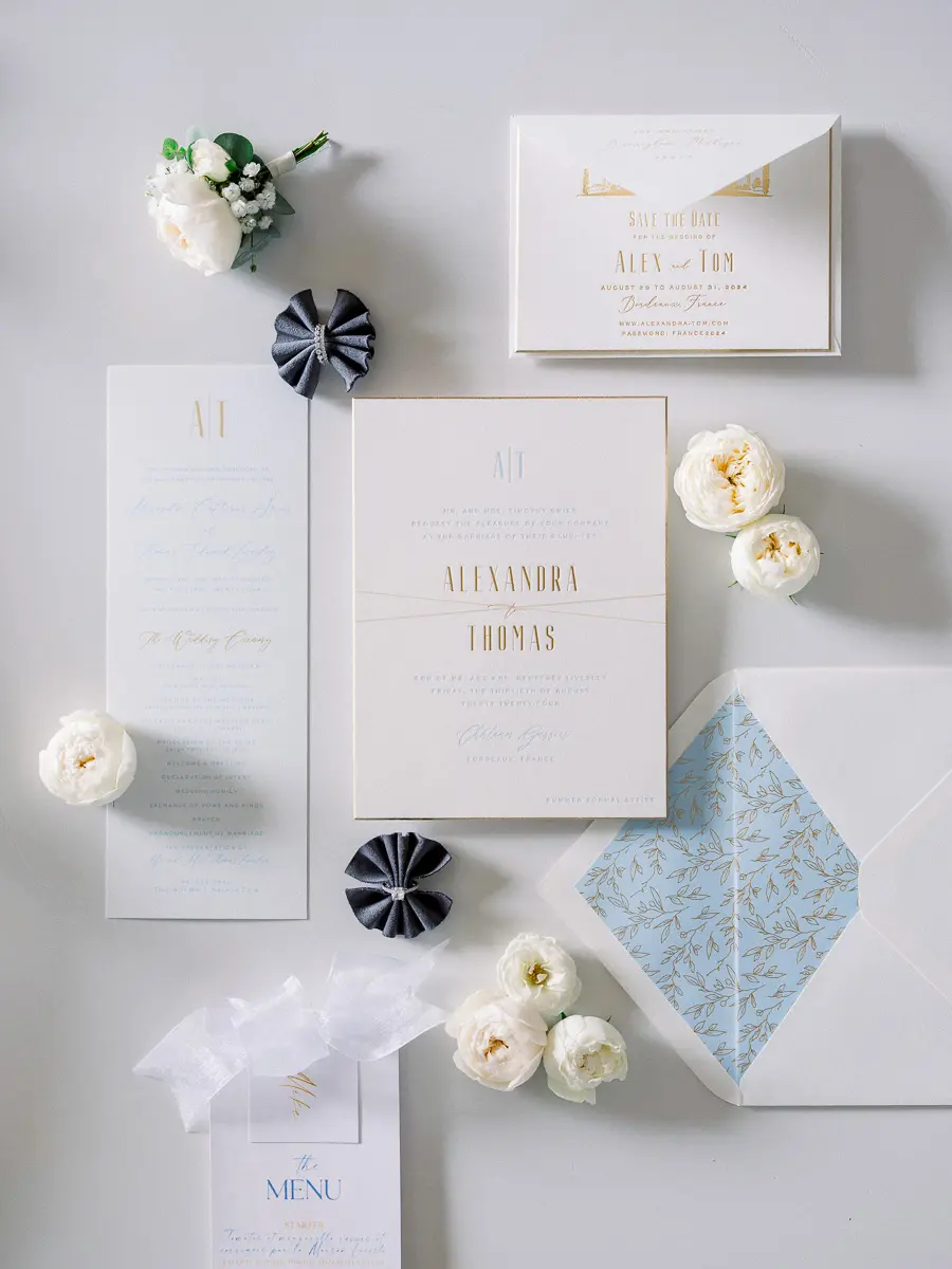 Wedding invitation suite with white roses and a blue patterned envelope liner