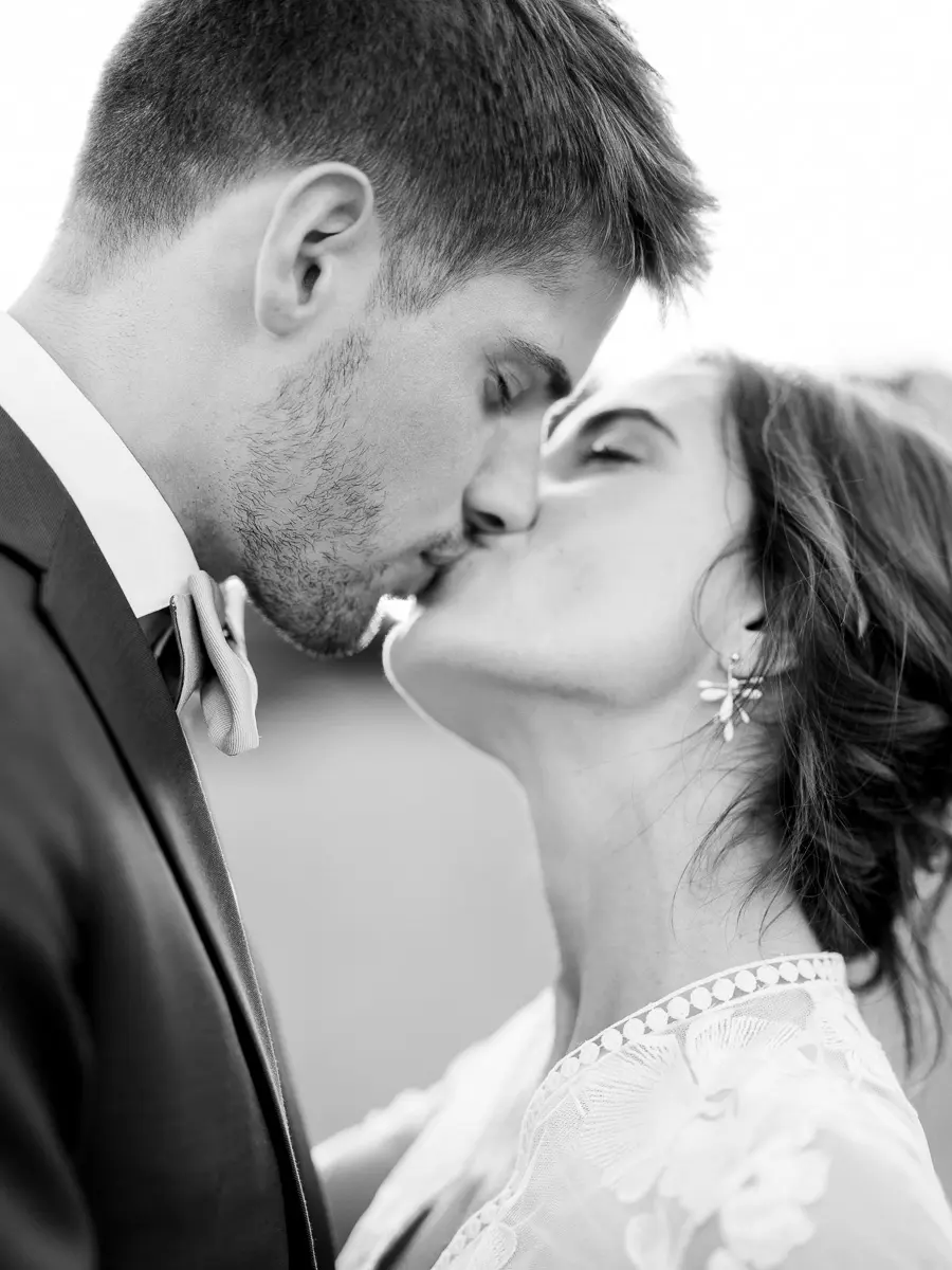 Baiser des mariés en gros plan, photographie de mariage en noir et blanc