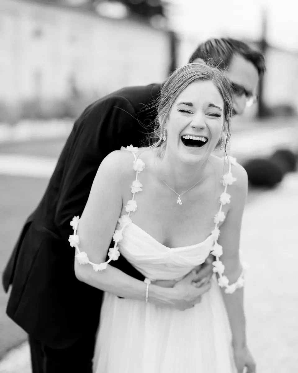 Mariée éclatant de rire dans les bras du marié, photo en noir et blanc à Bordeaux