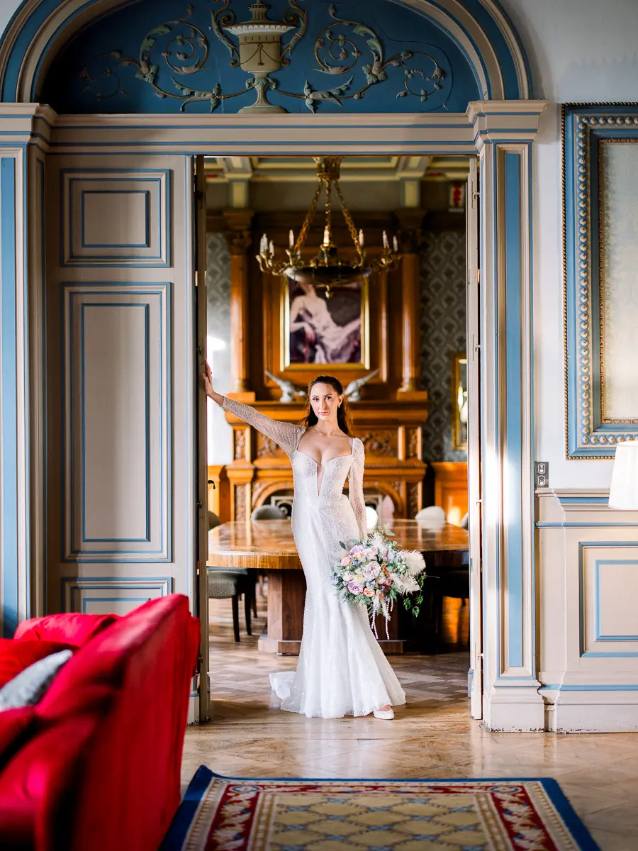 Mariée dans l'encadrement de la porte d'un salon de château