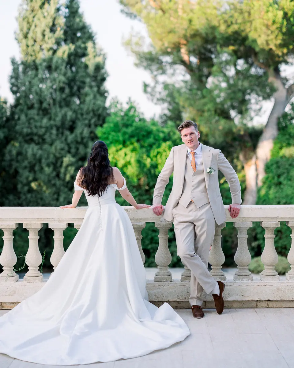 Mariée et marié sur la terrasse d'un château, devant une balustrade en pierre