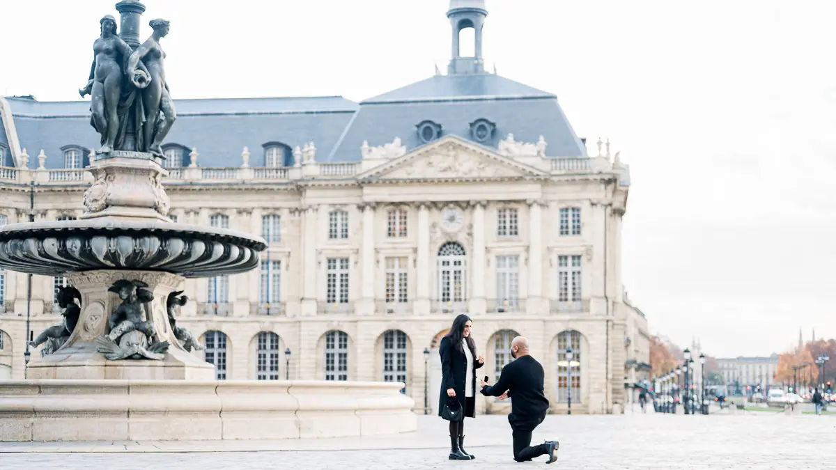 Marriage proposal, down on one knee, in front of the fountain on Place de la Bourse