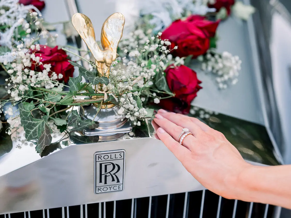 Bride's hand on the grille of a flower-decked Rolls-Royce, Château Gardemoulin